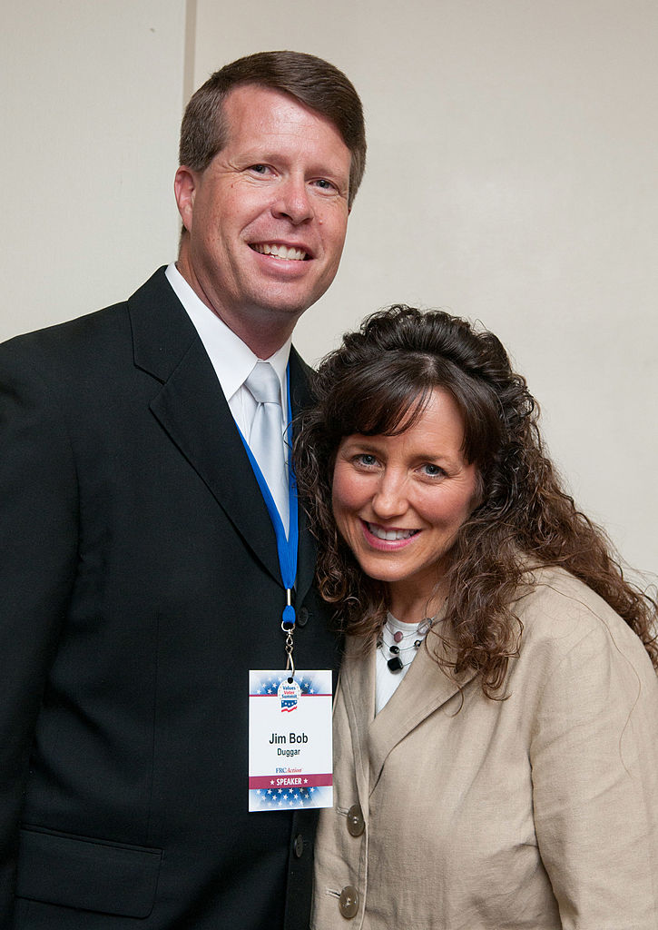 Jim Bob Duggar and Michelle Duggar pose for a photographer during a book signing