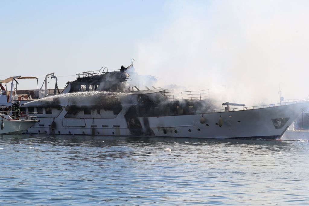 Firefighters spray water as they try to extinguish a fire erupted during the night on board a private yacht "Le Lalibela"