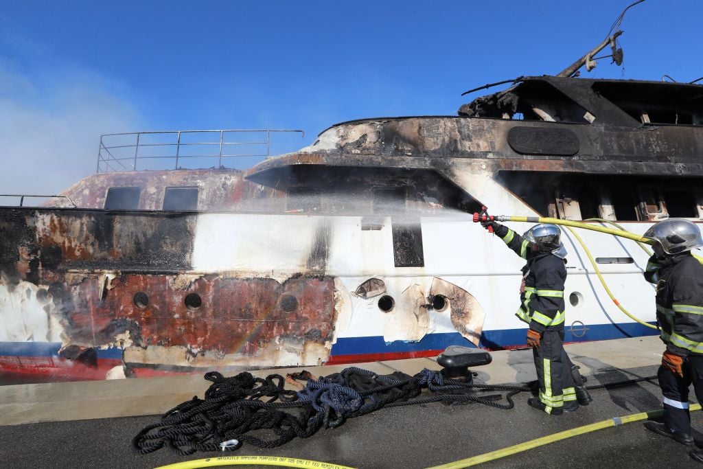 Firefighters spray water as they try to extinguish a fire erupted during the night on board a private yacht "Le Lalibela" on October 12, 2018 at the Vallauris harbour in Golf-Juan, southeastern France 