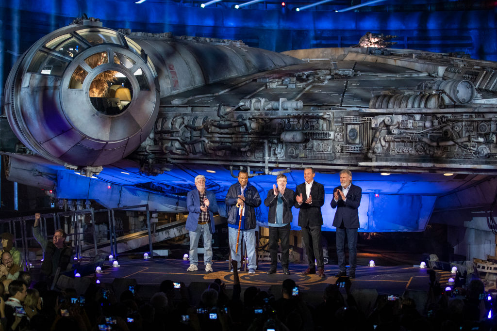 George Lucas, Billy Dee Williams, Mark Hamill, Bob Iger, and Harrison Ford in front of the Millennium Falcon at Star Wars: Galaxy's Edge in Disneyland.