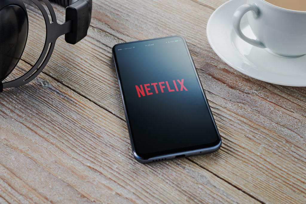Netflix logo visible on phone screen