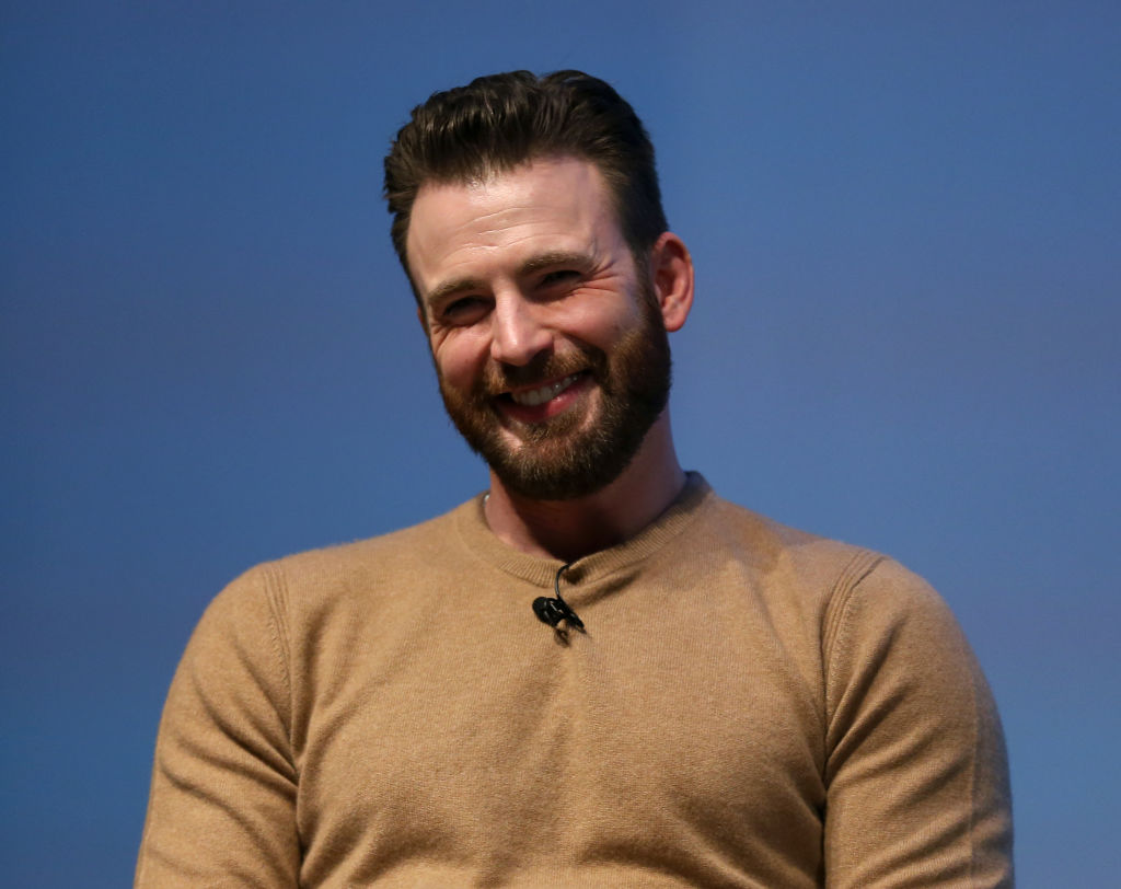 Chris Evans laughing in front of a blue background