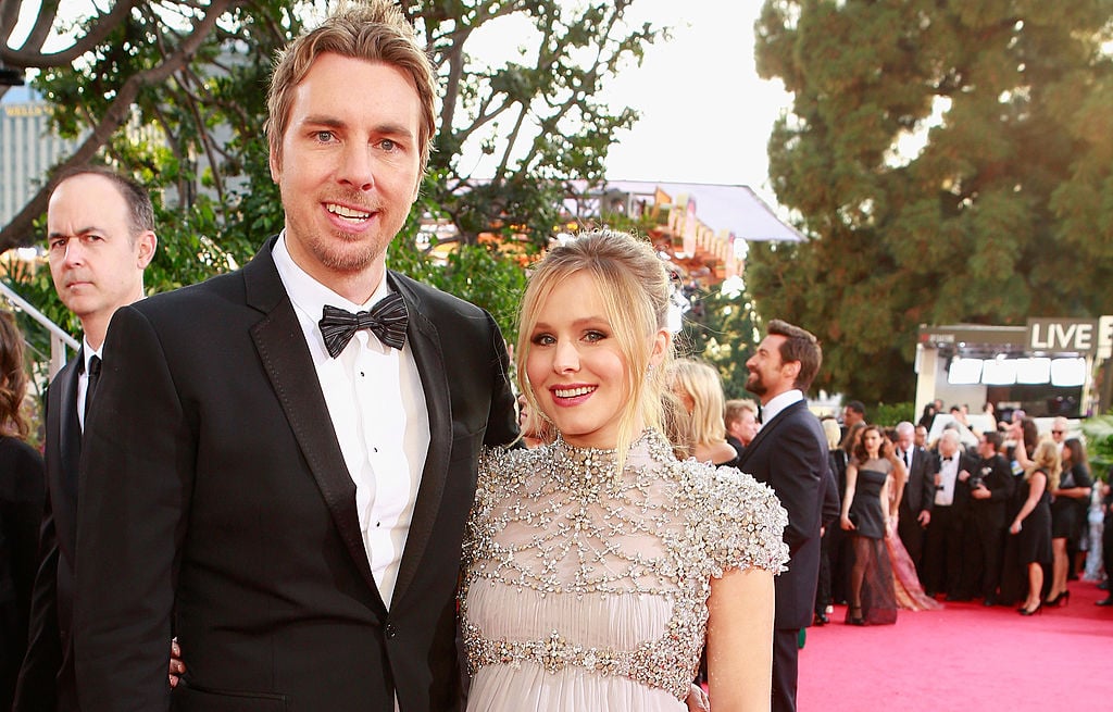 Dax Shepard and Kristen Bell smiling at a camera on the red carpet