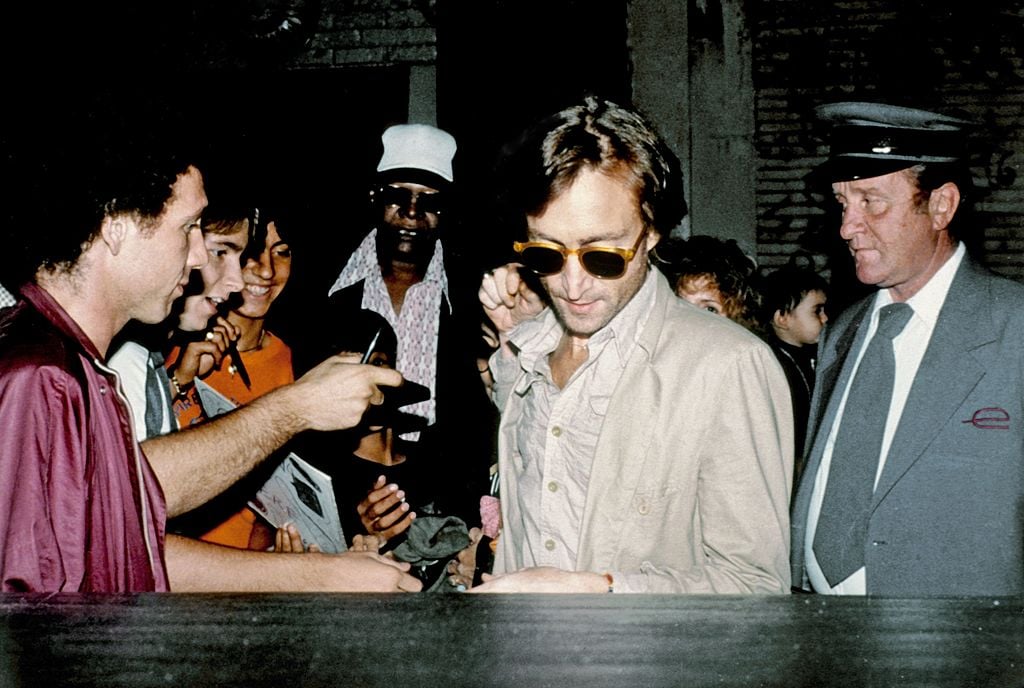 John Lennon in a crowd of people getting into a car