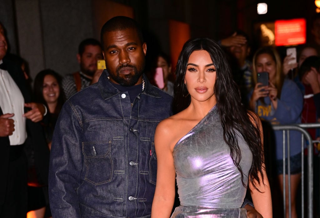Kanye West in a jean jacket and Kim Kardashian in a silver dress