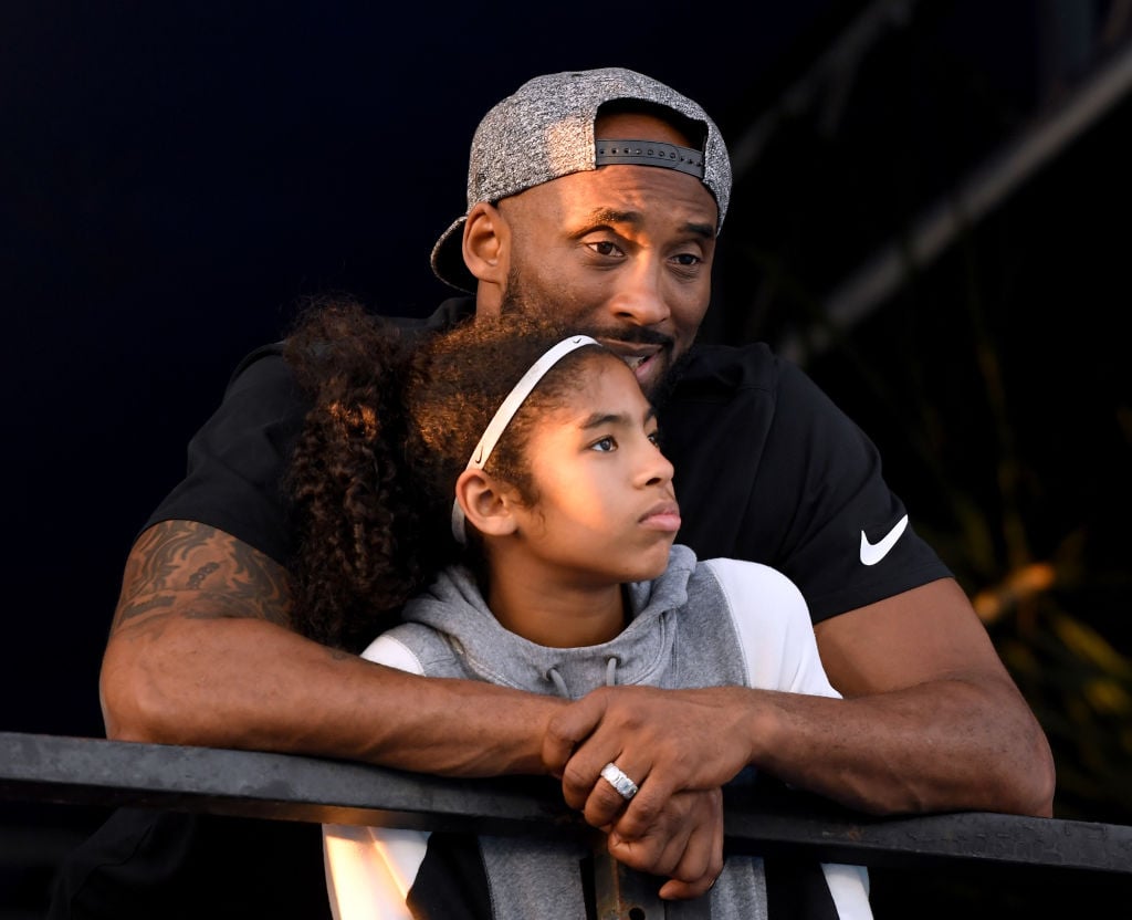 Kobe Bryant and daughter Gianna Bryant watch during day 2 of the Phillips 66 National Swimming Championships 