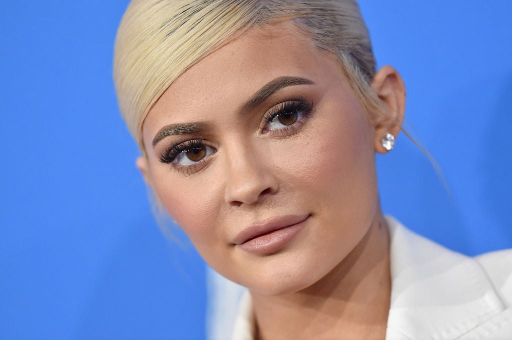 Kylie Jenner in front of blue backdrop.