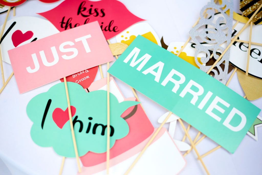 Signs that say 'Kiss the bride,' 'Just married,' and 'I love him'