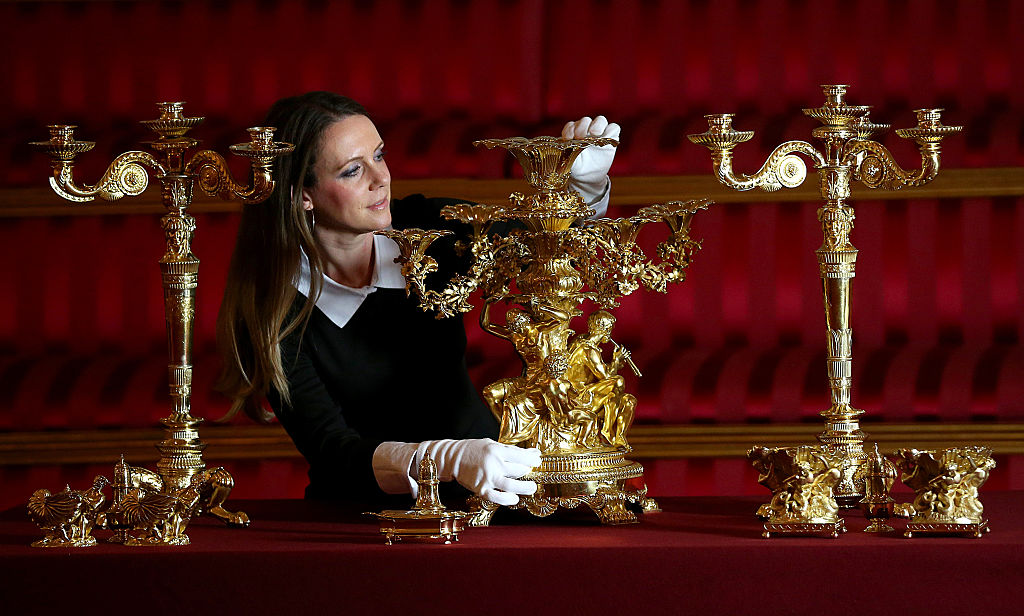 A member of Buckingham Palace's staff poses with items from Royal Collection on March 16, 2015