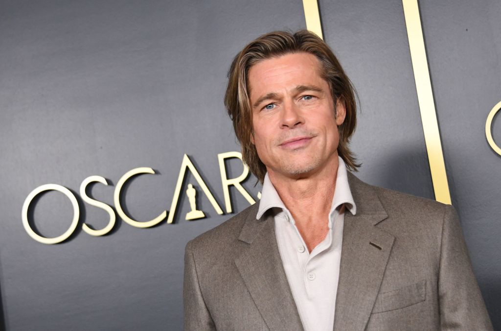 Brad Pitt poses for photos at an Oscars luncheon.