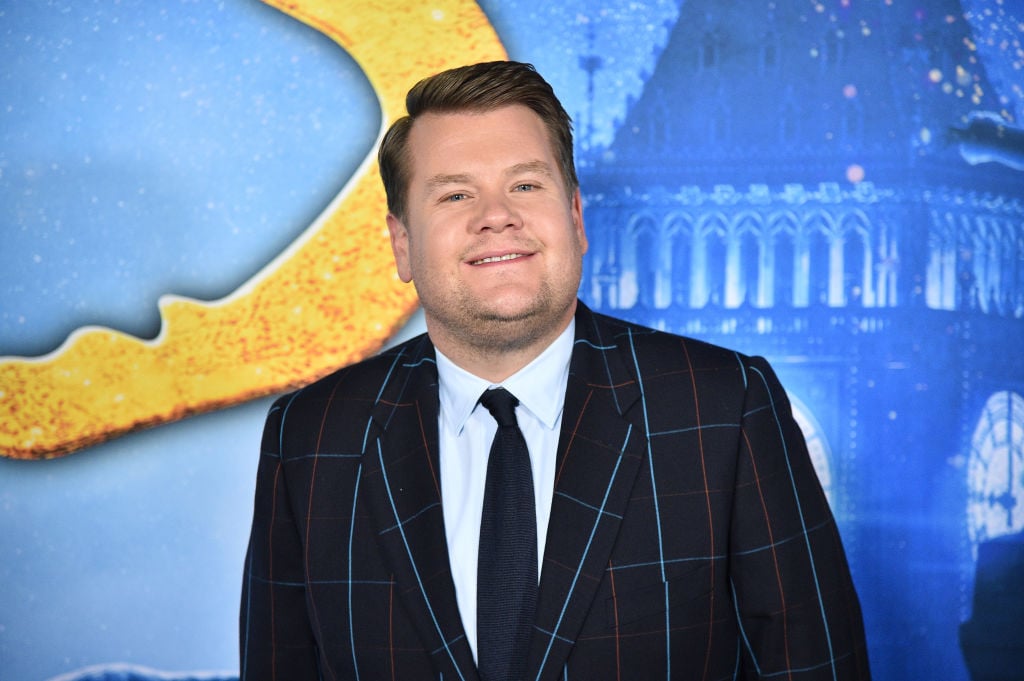 James Corden smiling in front of a 'Cats' background