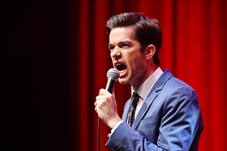John Mulaney performs on stage