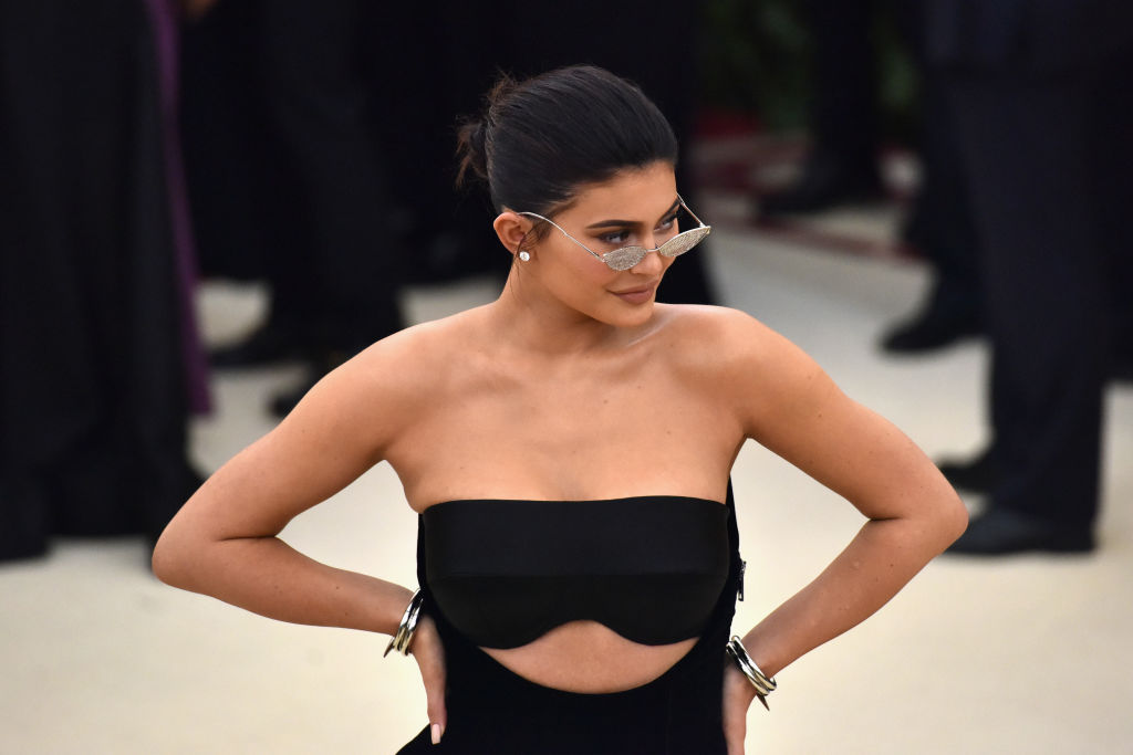 Kylie Jenner wearing sunglasses and a black dress, looking to the right