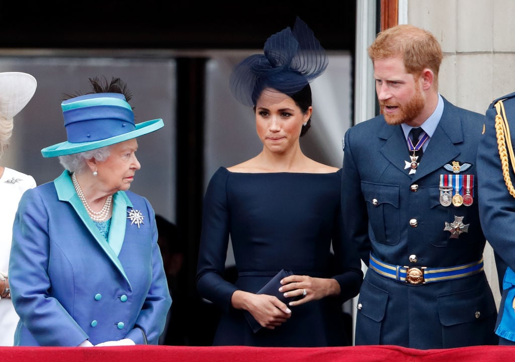 Queen Elizabeth II, Meghan Markle, and Prince Harry watch a flypast to mark the centenary of the Royal Air Force from the balcony of Buckingham Palace on July 10, 2018 in London, England. The 100th birthday of the RAF, which was founded on on 1 April 1918, was marked with a centenary parade with the presentation of a new Queen's Colour and flypast of 100 aircraft over Buckingham Palace. (Photo by Max Mumby/Indigo/Getty Images)