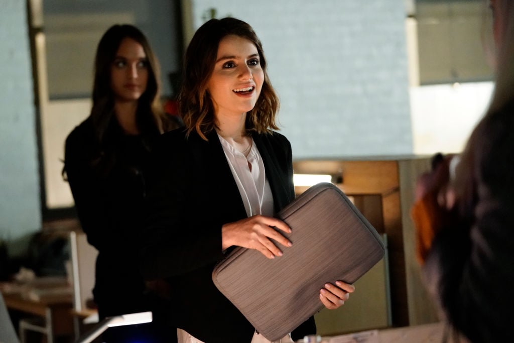 Sami Gayle smiling, holding a gray laptop case
