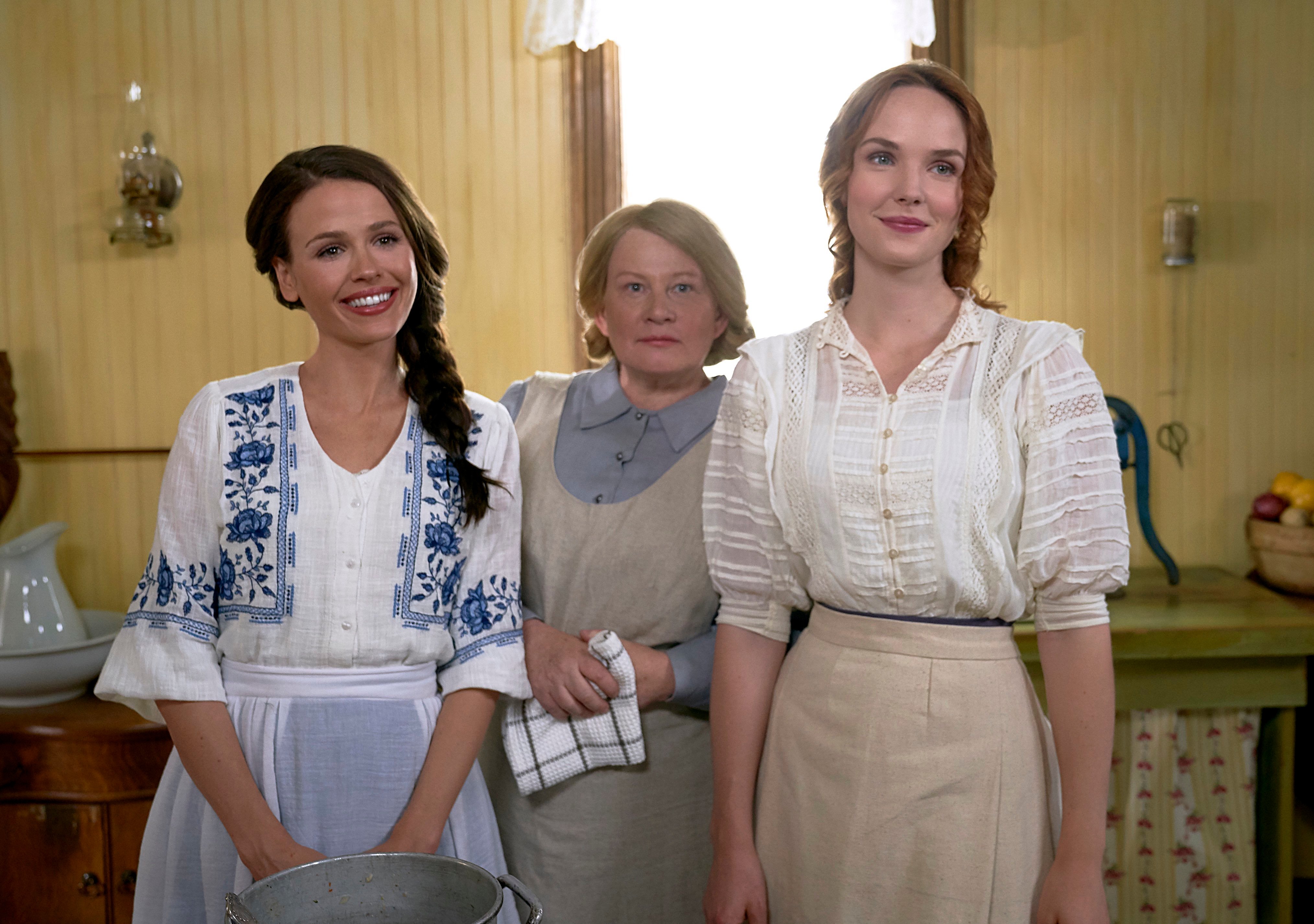 Grace and Lillian smiling with older woman in apron behind them in When Hope Calls 