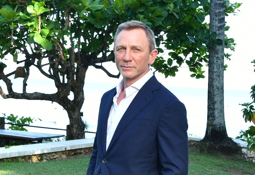 Daniel Craig smiling in front of trees