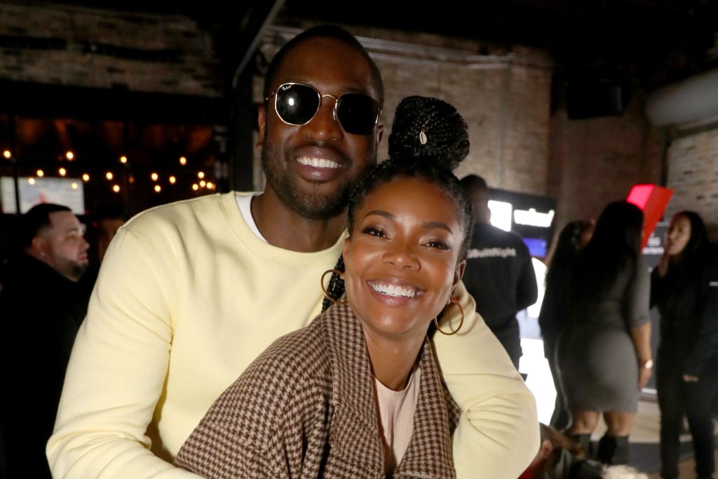 Gabrielle Union and Dwyane Wade embracing, smiling at the camera