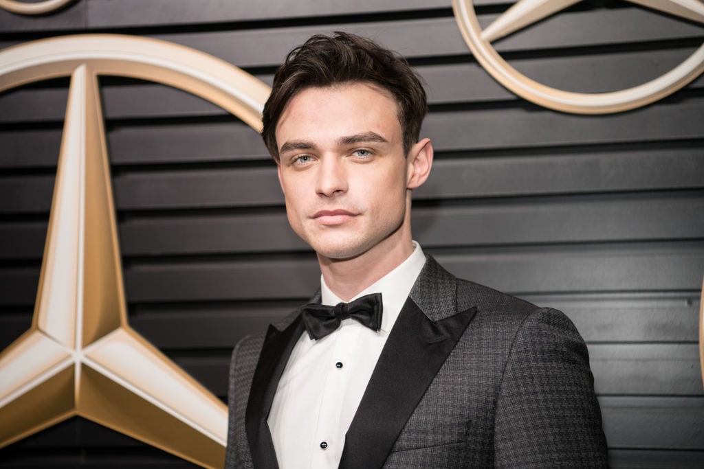 Thomas Doherty of the new 'Gossip Girl' cast in front of a repeating background in a tux