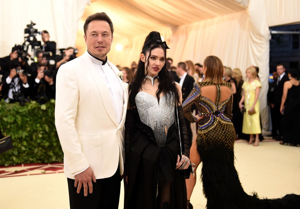Elon Musk with his arm slightly around Grimes