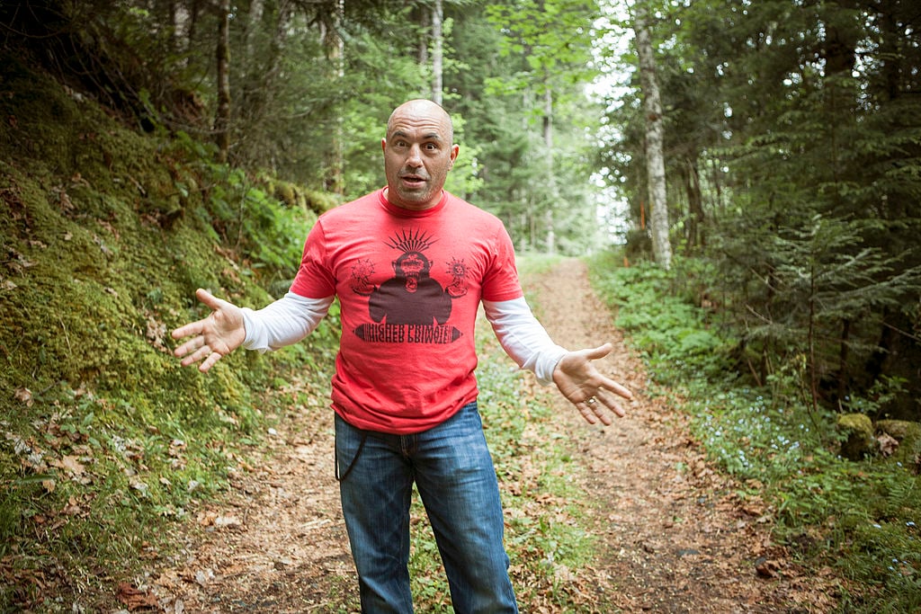 Joe Rogan in a red t-shirt on a wooded trail