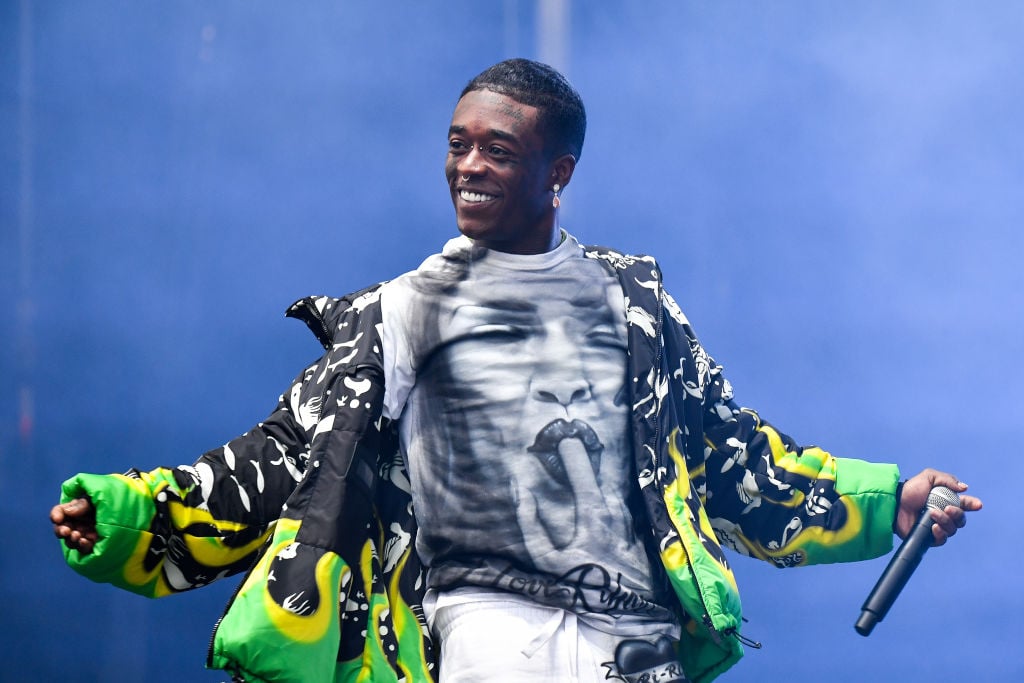 Lil Uzi Vert on stage holding a microphone and smiling