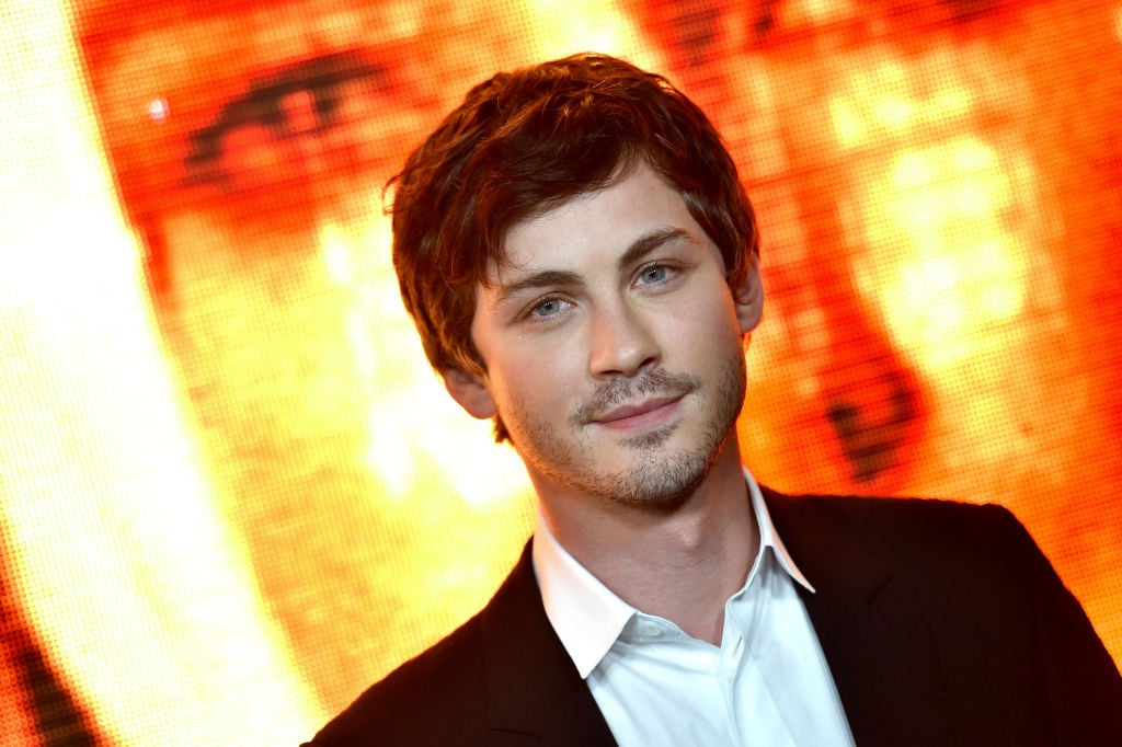 Logan Lerman in front of an orange background