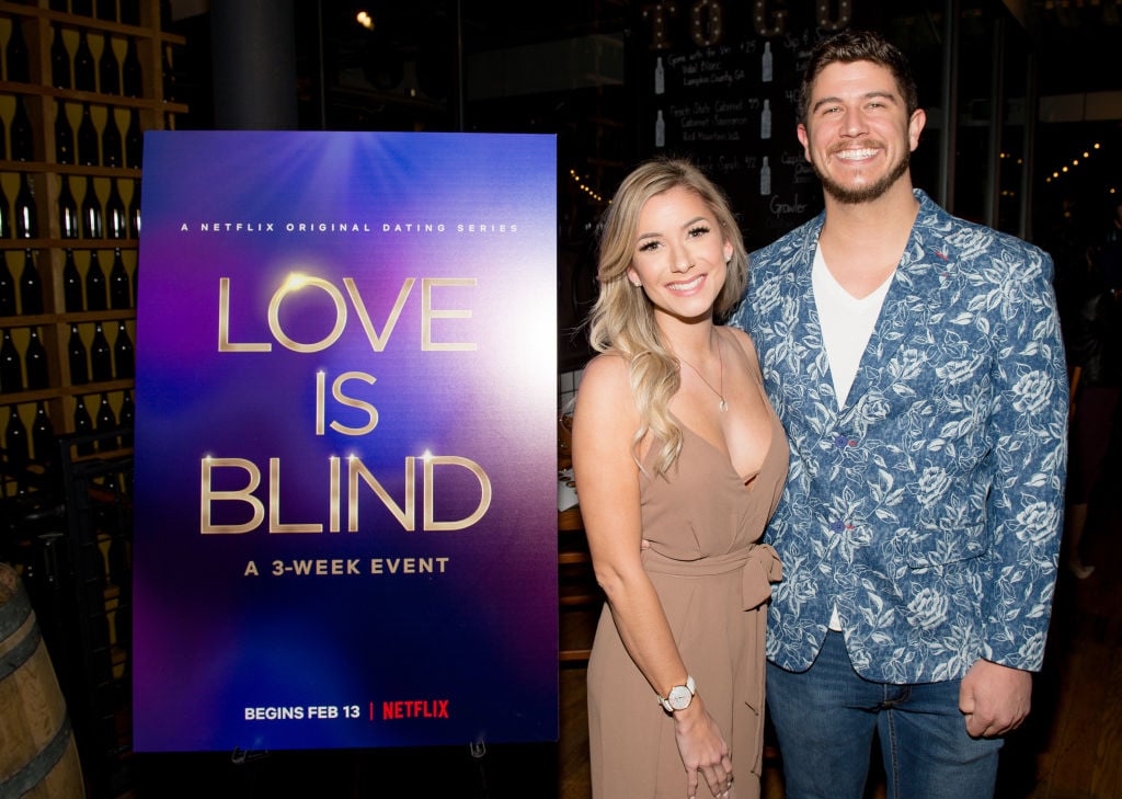 Amber Pike and Matt Barnett from 'Love is Blind' next to a promo sign
