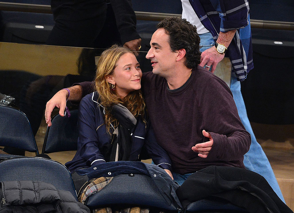Mary-Kate Olsen smiling at Olivier Sarkozy in courtside seats