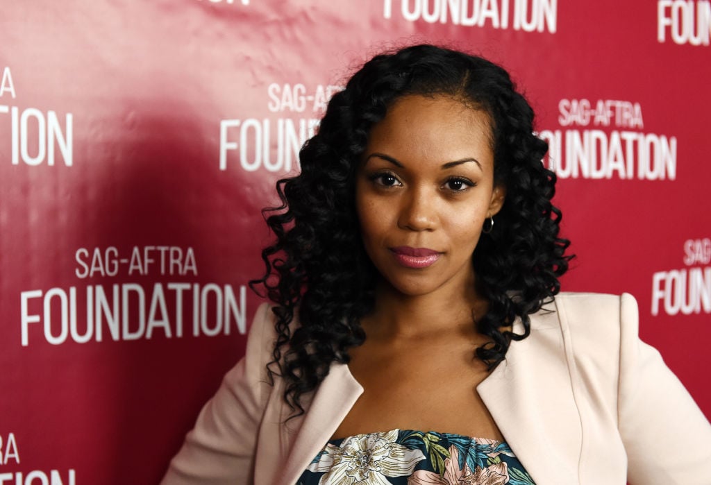 Mishael Morgan in front of a repeating background