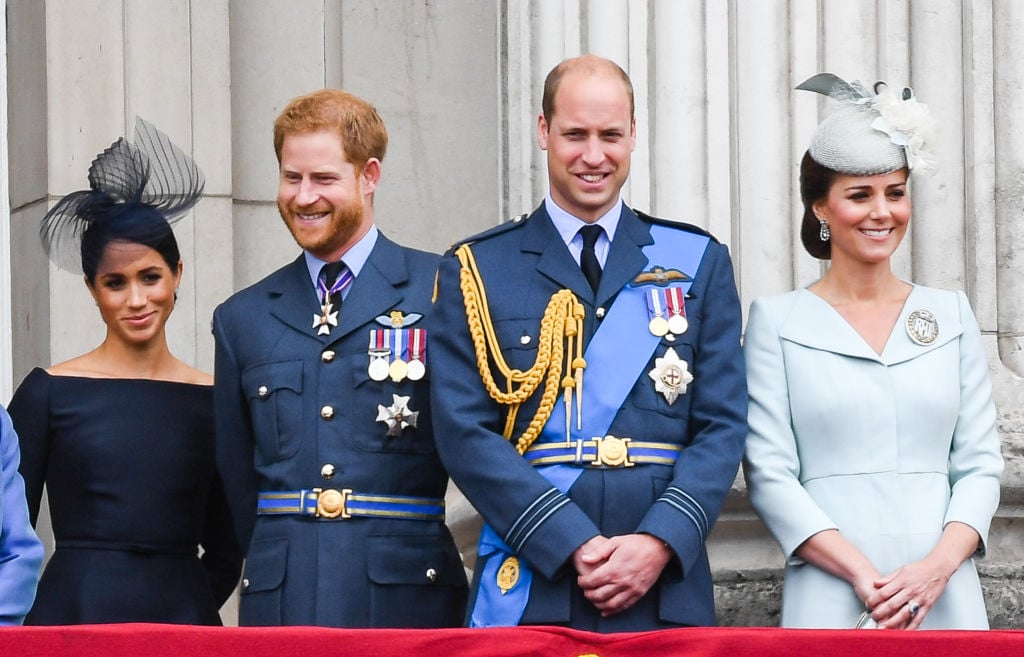 Meghan Markle, Prince Harry, Prince William, and Kate Middleton stand on the balcony of Buckingham Palace to view a flypast to mark the centenary of the Royal Air Force (RAF