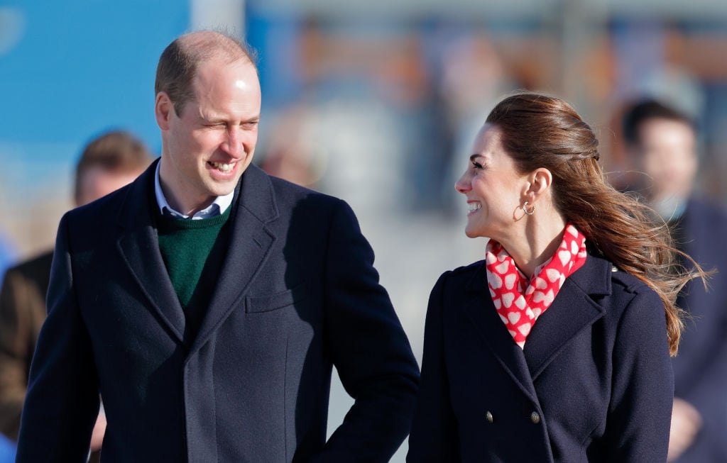 Prince William, slightly turned, smiling at Kate Middleton