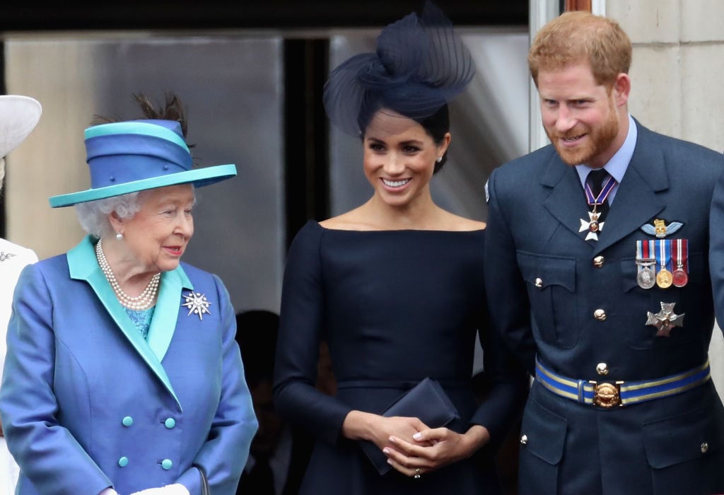 Queen Elizabeth II, Meghan Markle, and Prince Harry watch the RAF flypast on the balcony of Buckingham Palace