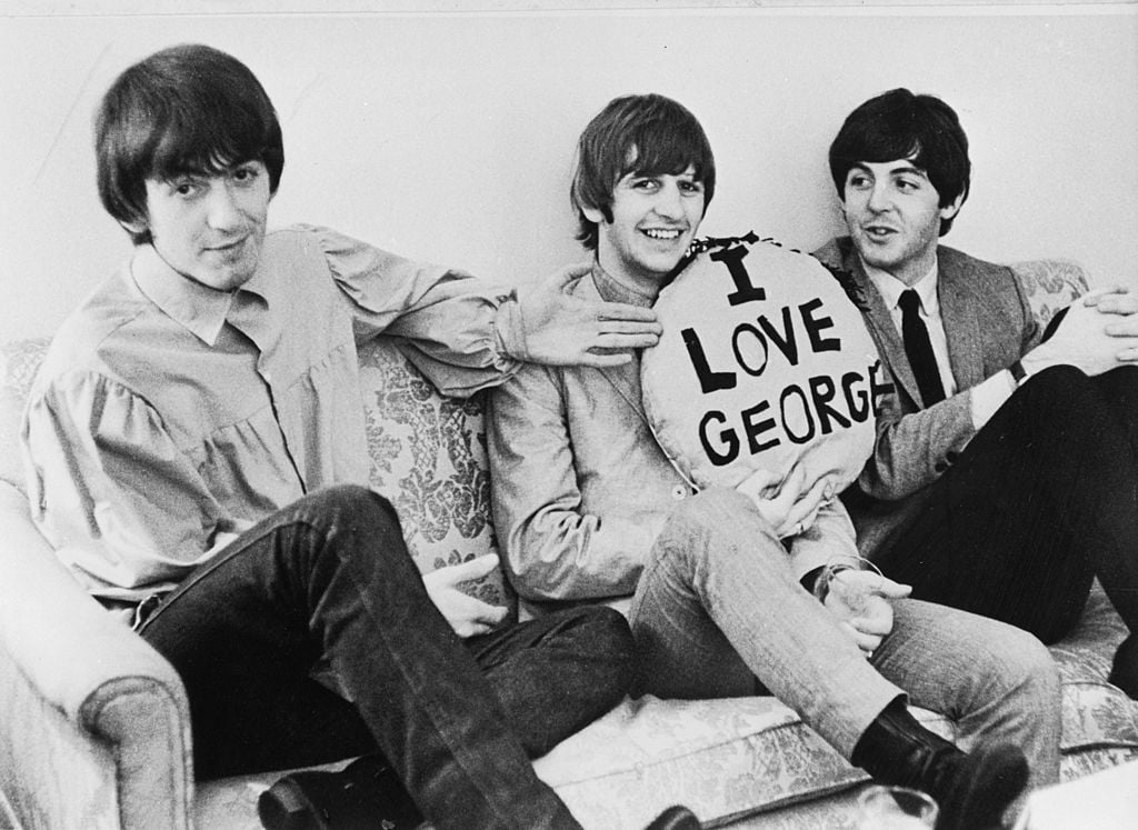 Rongo Starr, Paul McCartney, and George Harrison with an "I Love George" pillow