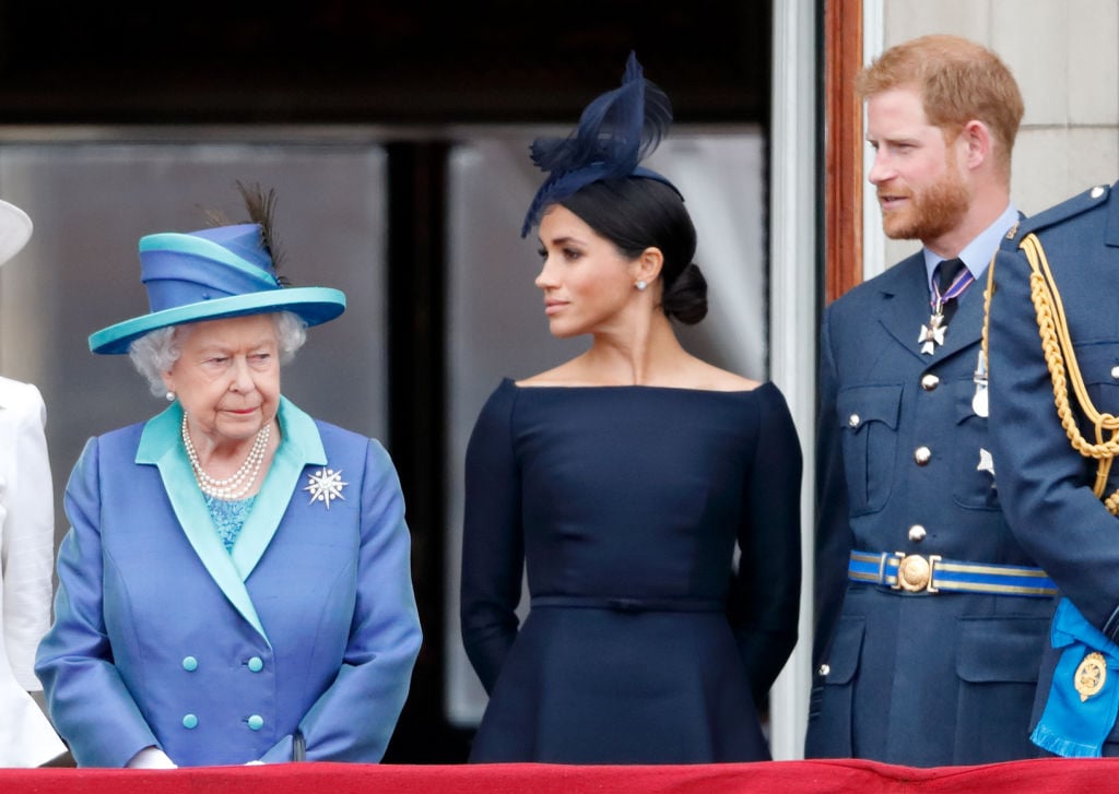 Queen Elizabeth II, Meghan Markle, and Prince Harry watch a flypast to mark the centenary of the Royal Air Force from the balcony of Buckingham Palace