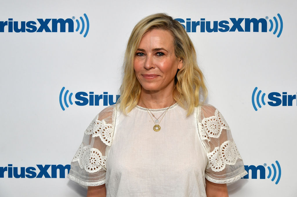 Chelsea Handler smiling in front of a repeating background