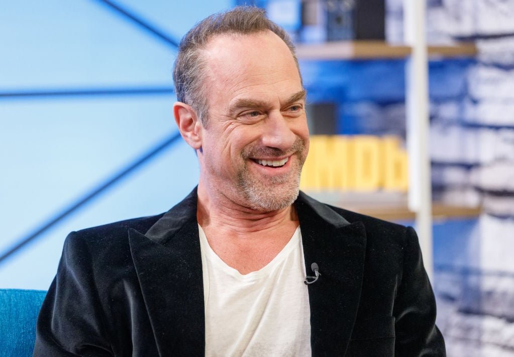 Christopher Meloni smiling with his head turned away from the camera