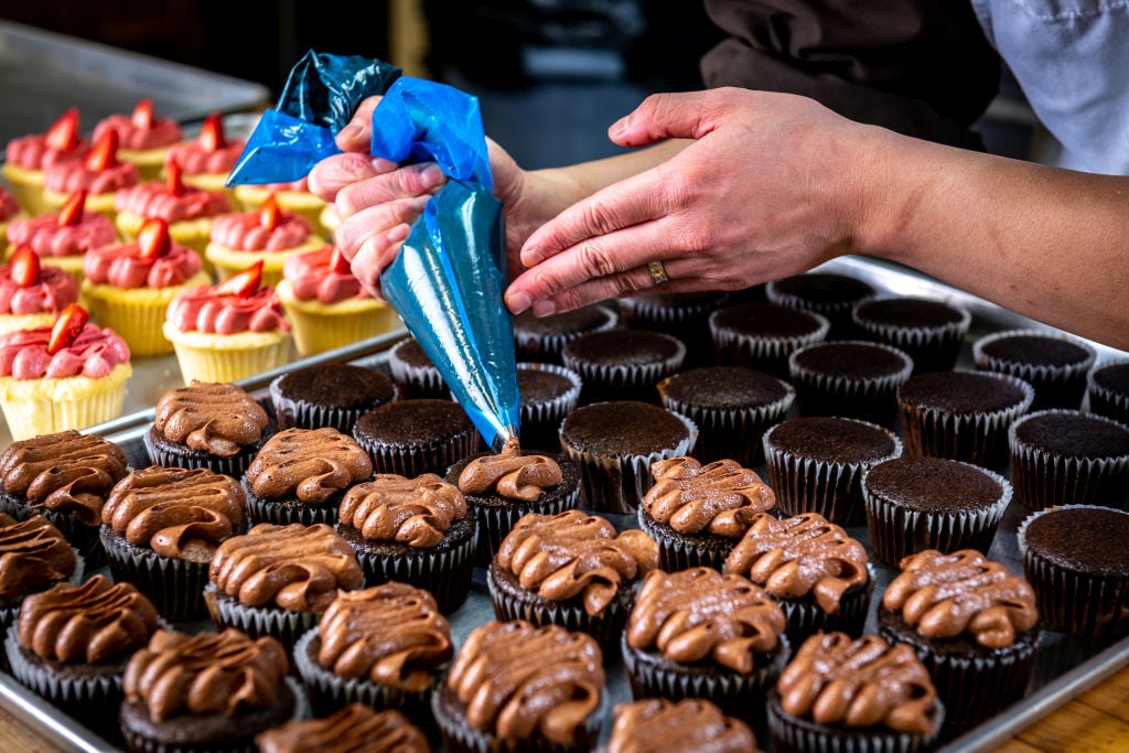 Closeup of cupcakes being frosted