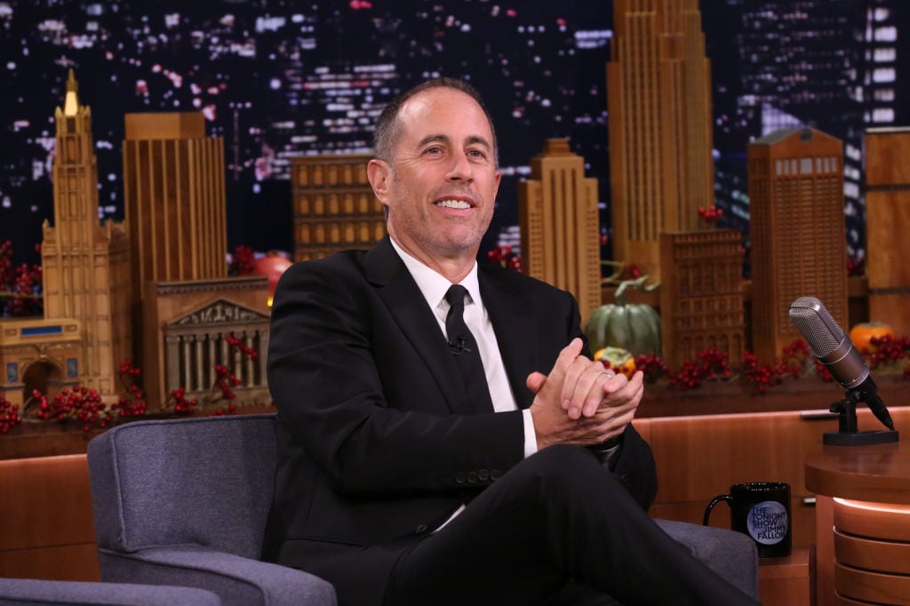 Jerry Seinfeld smiling in a chair