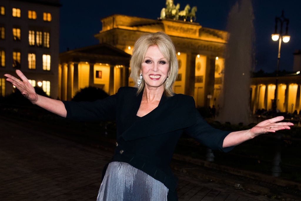 Joanna Lumley smiling with her arms outstretched