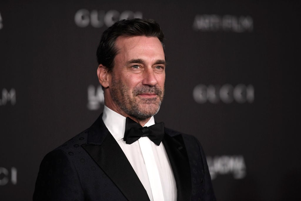 Jon Hamm smiling looking off camera in a tuxedo