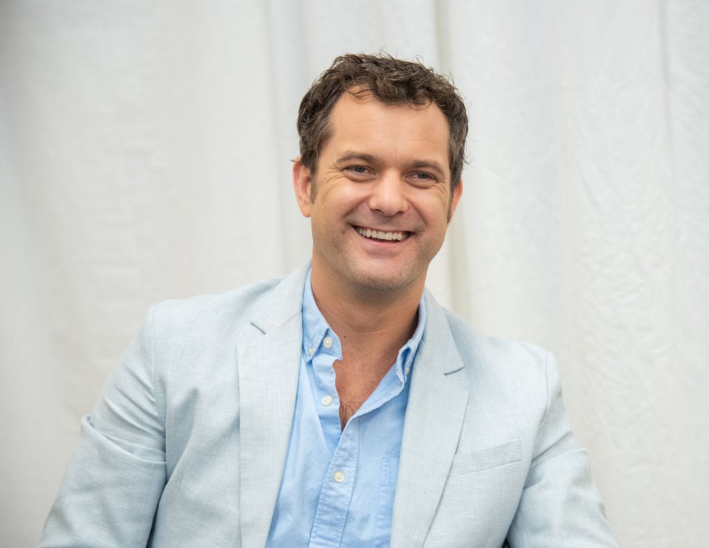 Joshua Jackson smiling in an off white jacket