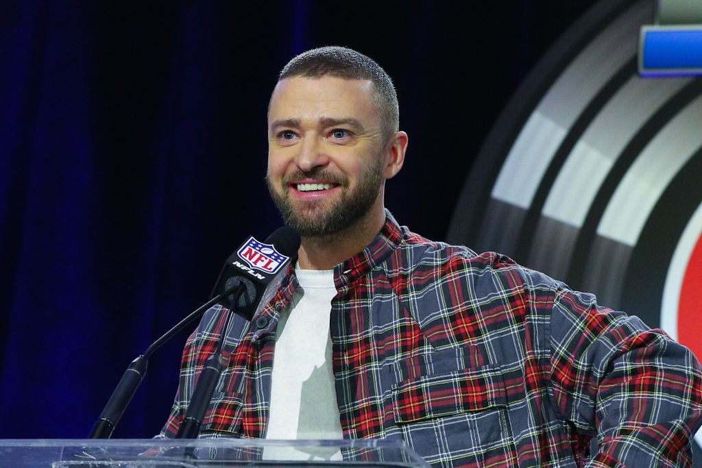 Justin Timberlake smiling in front of a mic with an NFL logo