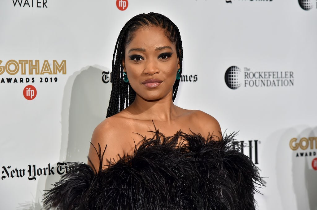 Keke Palmer smiling in front of a repeating background