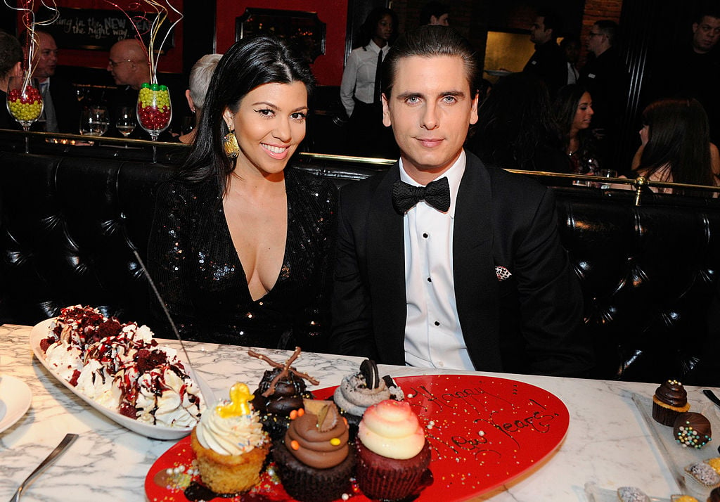Kourtney Kardashian and Scott Disick in formalwear in front of desserts