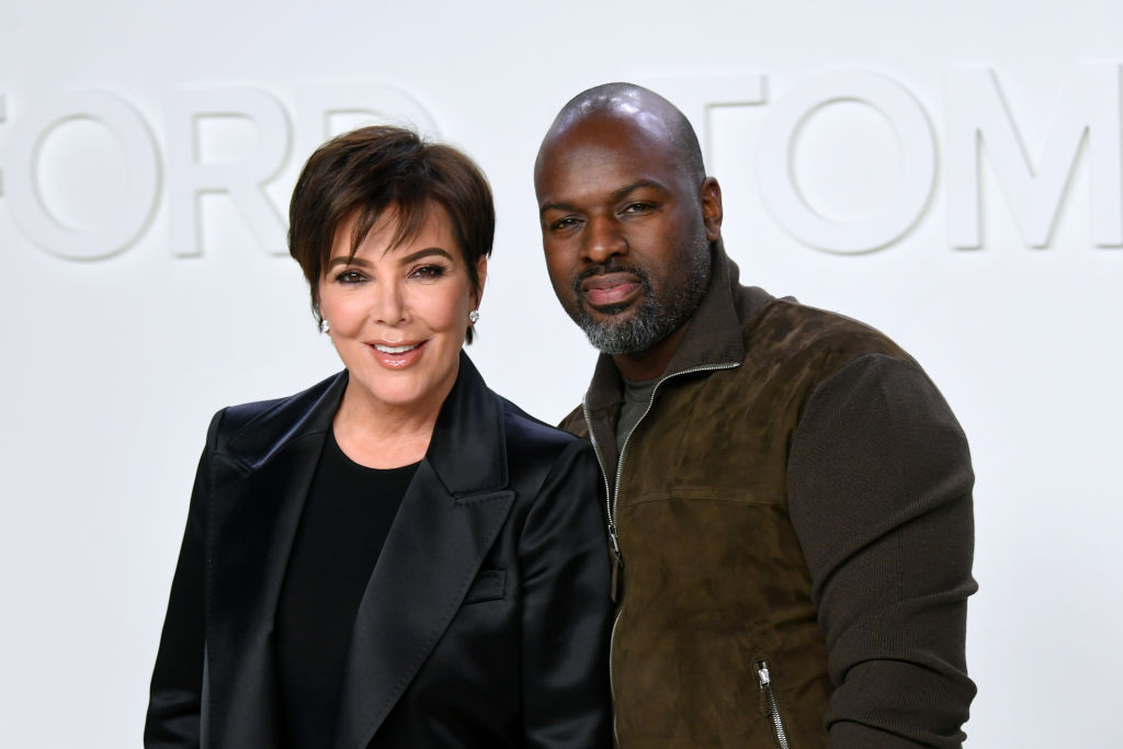 Kris Jenner and Corey Gamble smiling in front of a white background