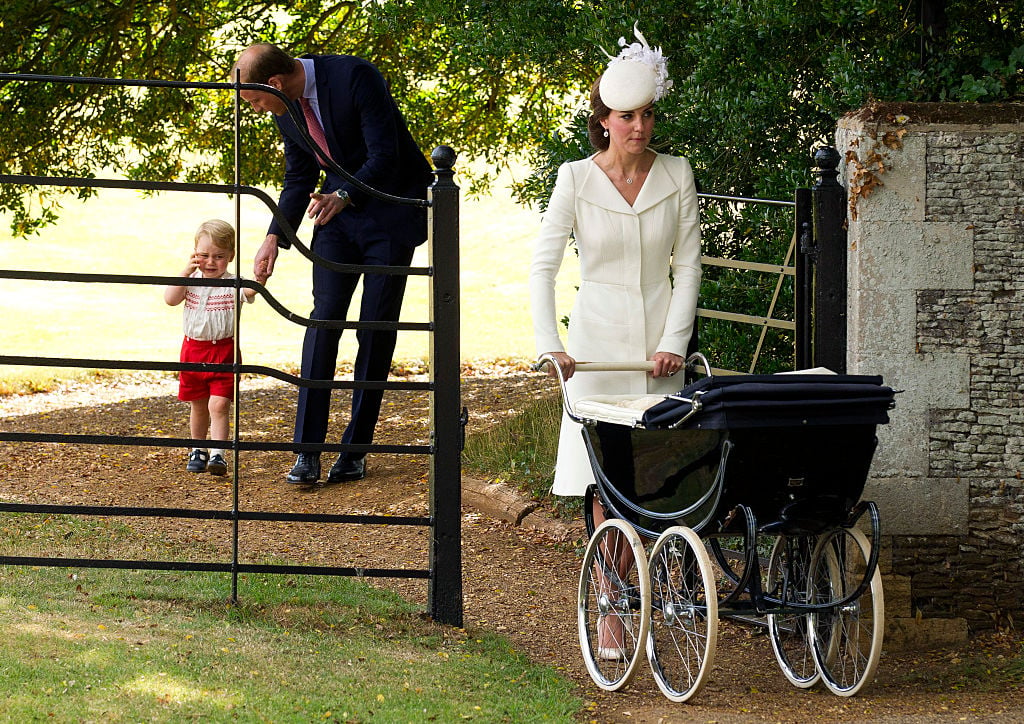 Prince William walks with Prince George while Kate Middleton pushes Princess Charlotte in a stroller