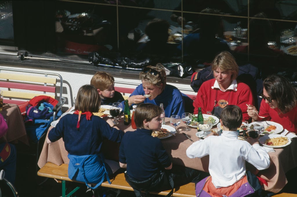 Princess Diana, Prince Harry, and Prince William having lunch with friends on a ski trip