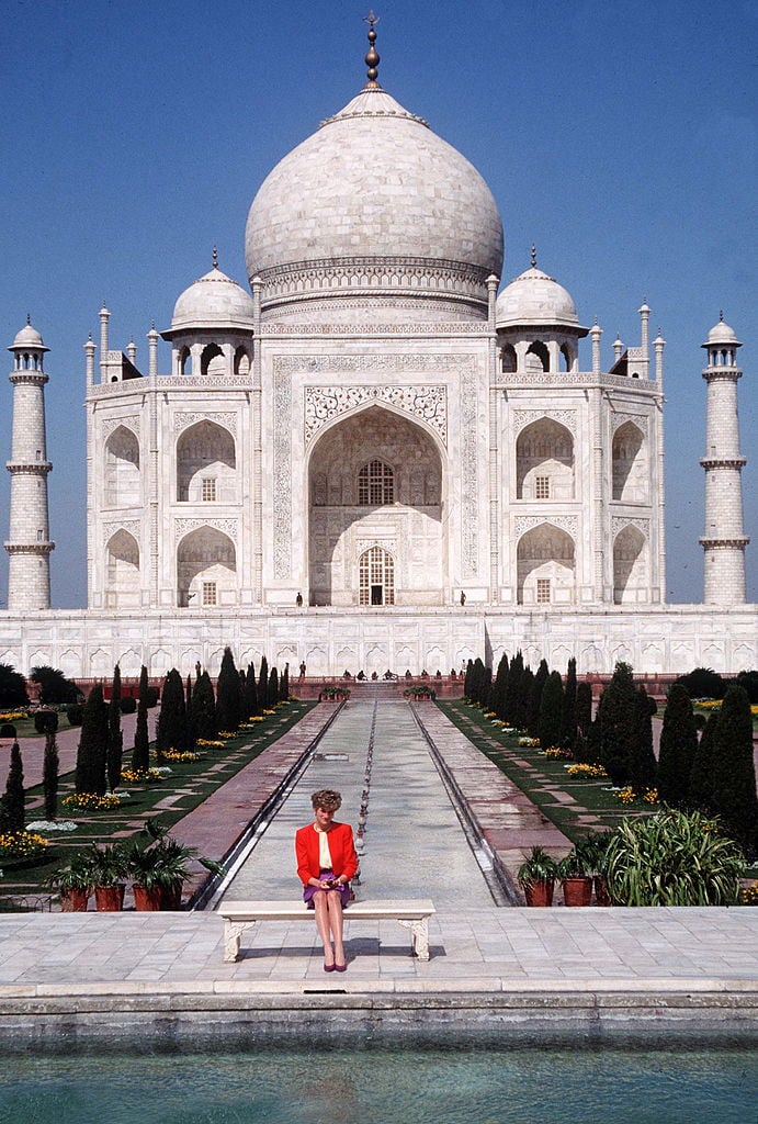 Princess Diana sits on a bench in front of the Taj Mahal