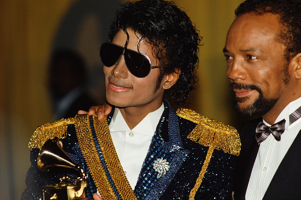 Quincy Jones in a suit next to Michael Jackson, the singer of "Billie Jean"